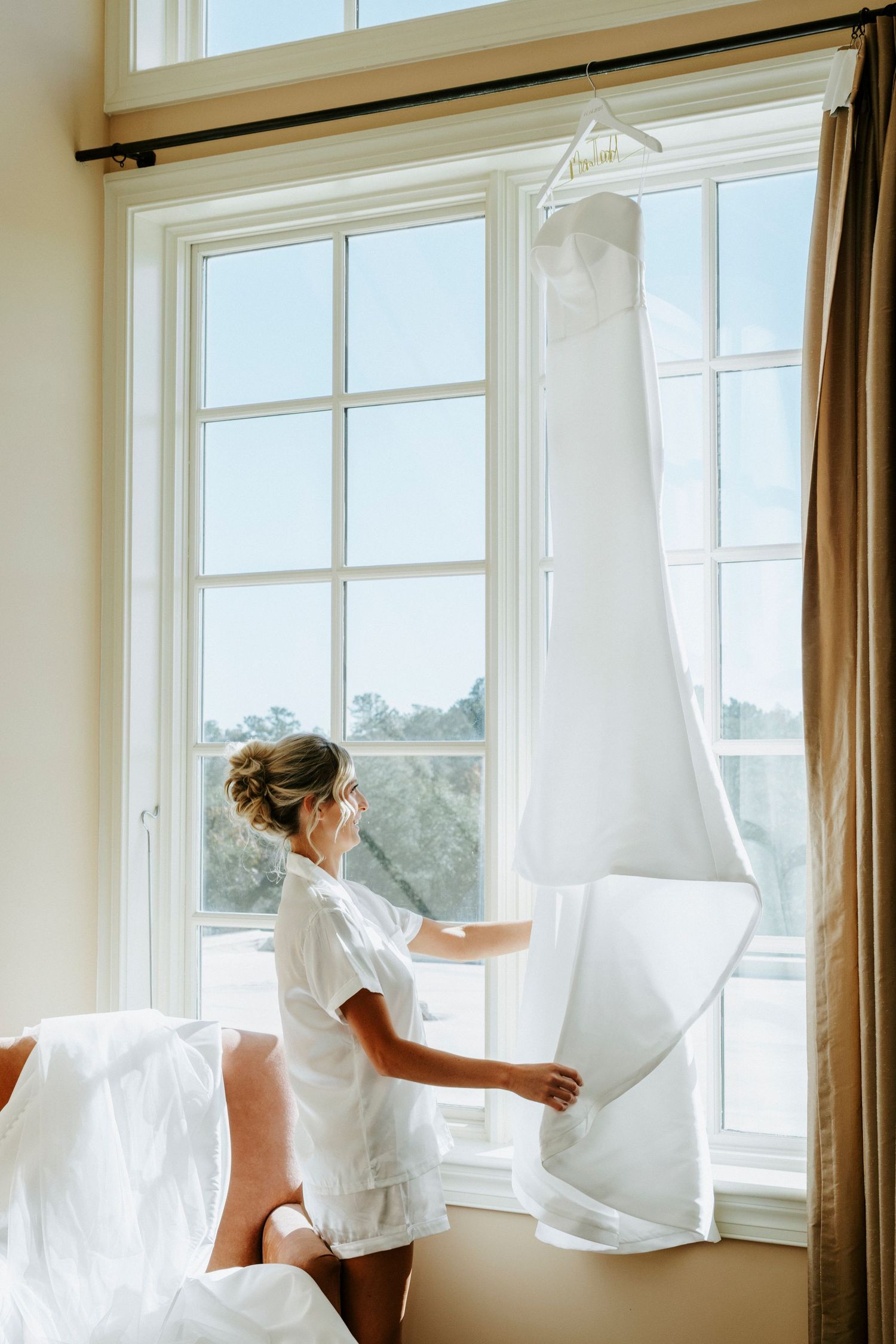White curtains billowing in the breeze through multiple windows in a bright, sunlit room.