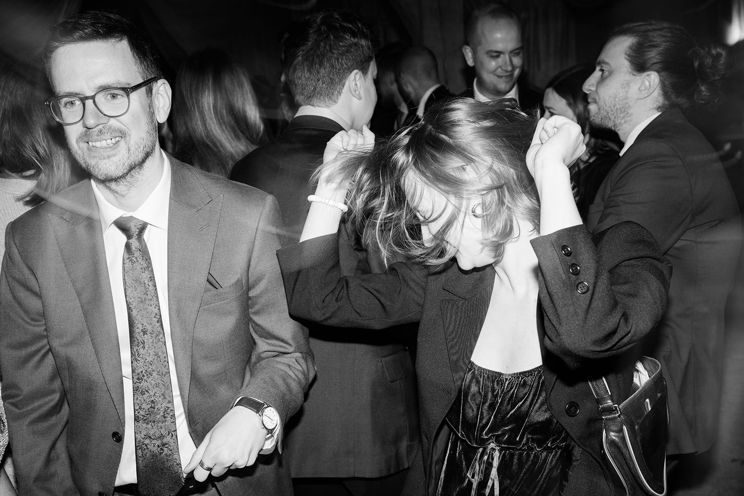 A series of black and white photographs showing people in formal attire at what appears to be a social gathering or event.
