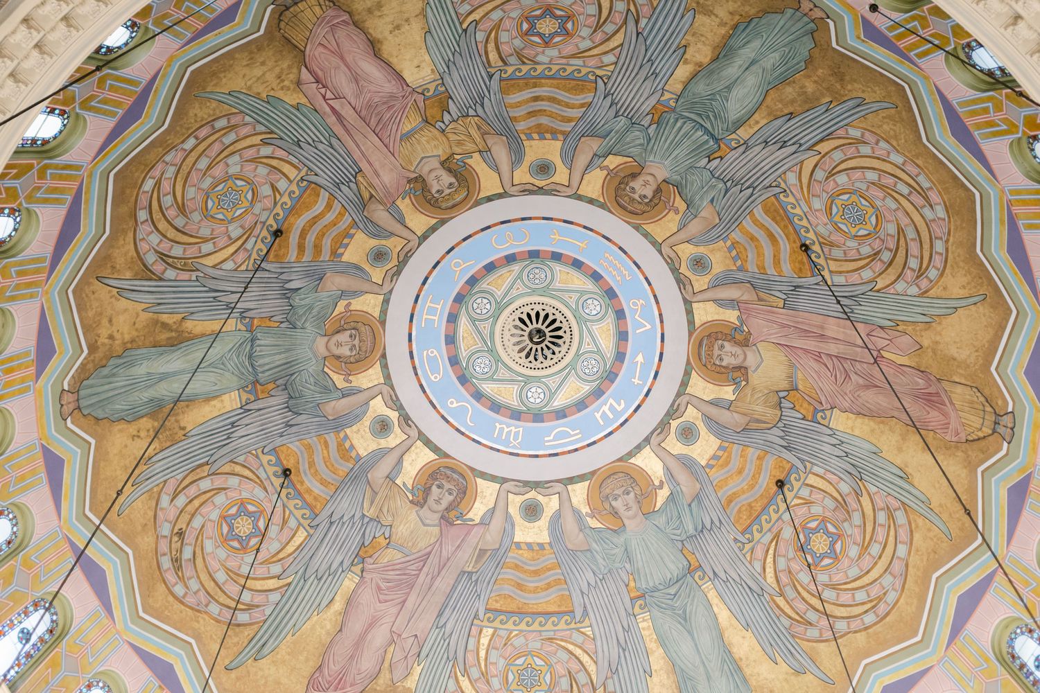 Ornate baroque church dome ceiling with pastel frescoes and intricate spiral patterns radiating from a central medallion.