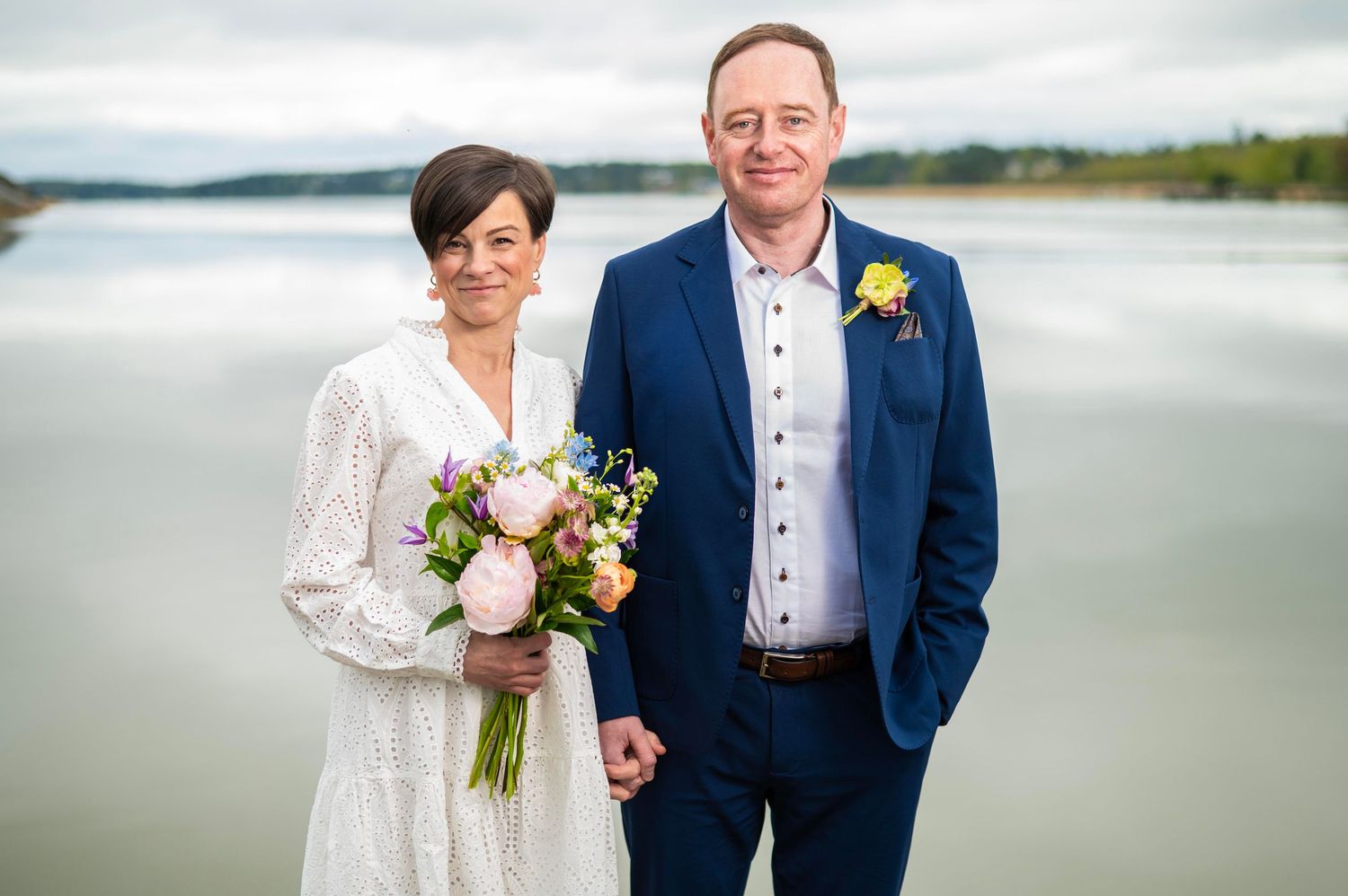 Hääpari seisoo laiturilla Turun uittamon rannassa.