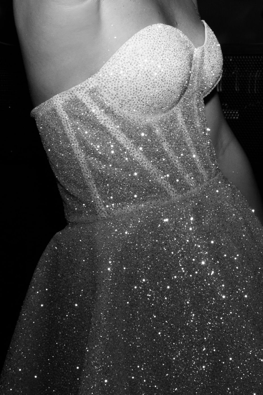 Bröllopsfotograf Emelie Petré, Villa Frdihem. Close-up detail of a sparkly white wedding dress bodice with glittering sequins and beading.