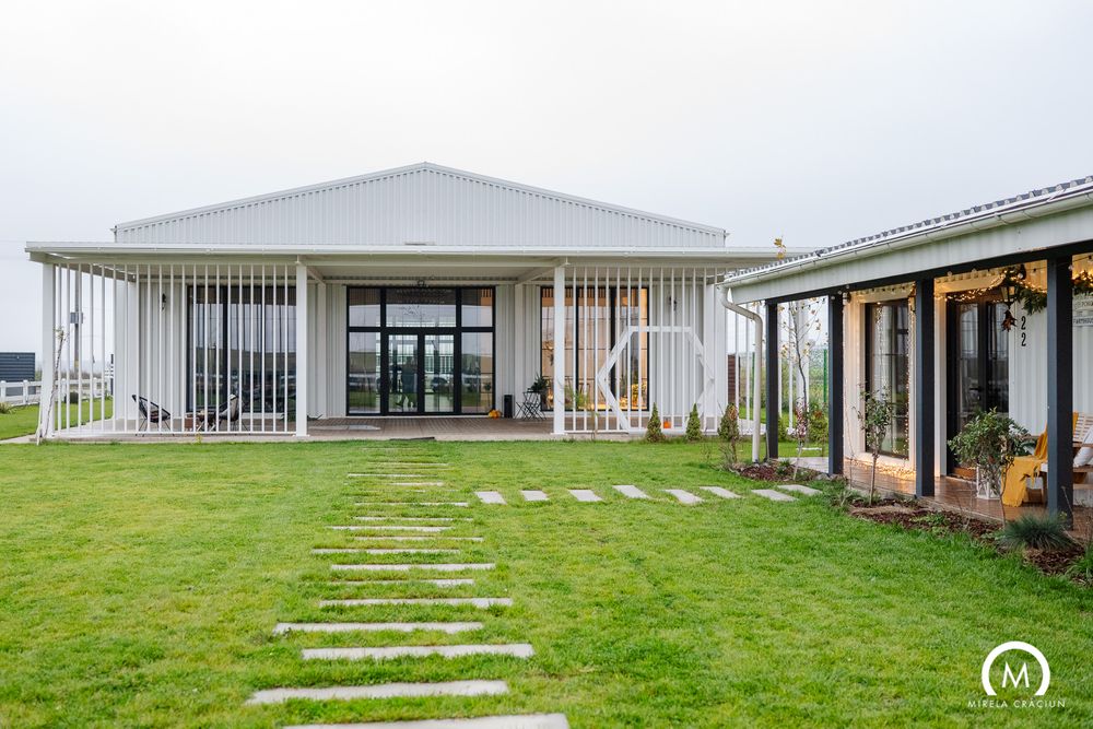 Modern white building complex with grassy lawn and concrete stepping stones creating a pathway through the landscape.