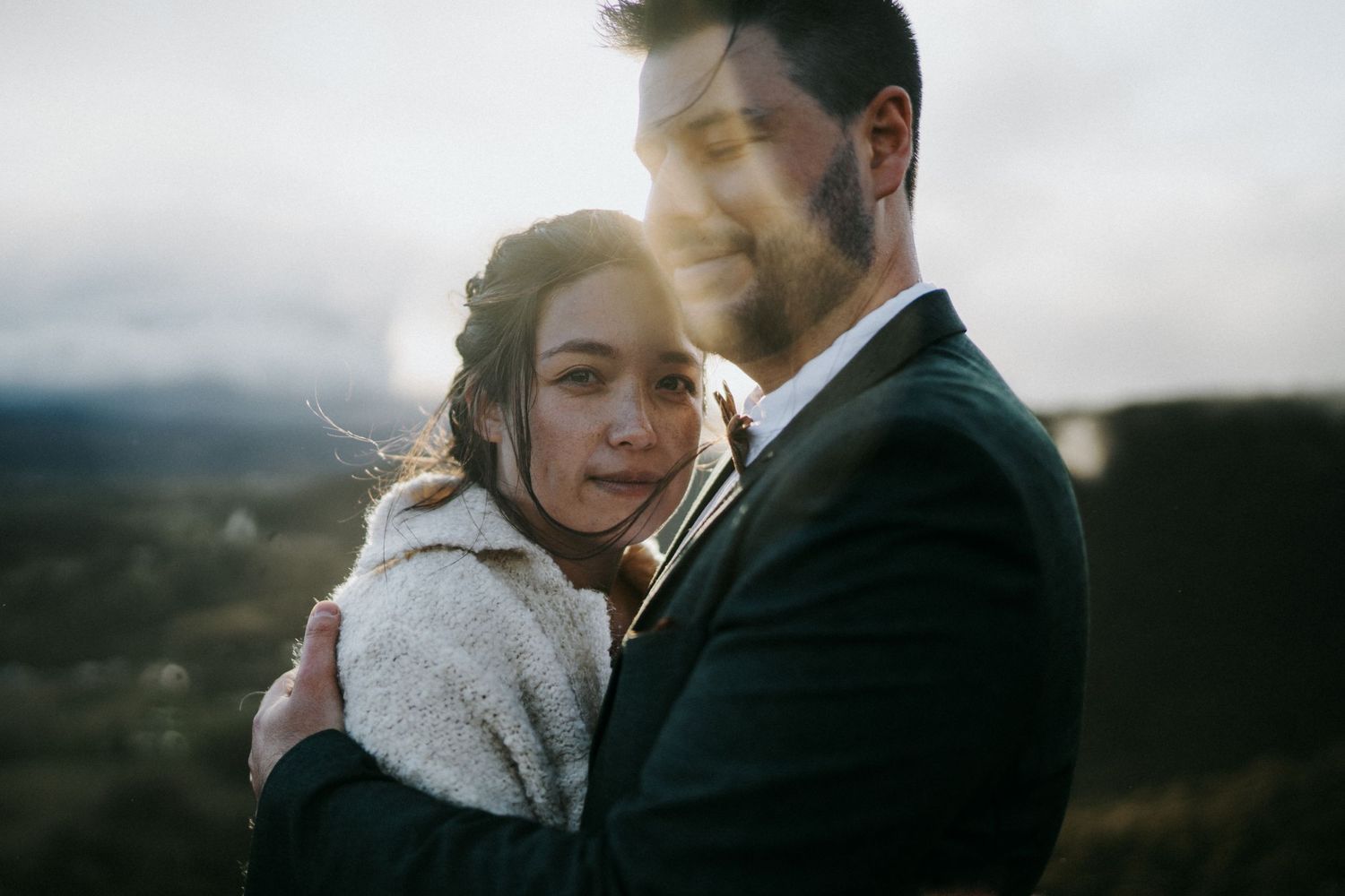 Intimate winter wedding portraits captured against a moody mountain landscape.