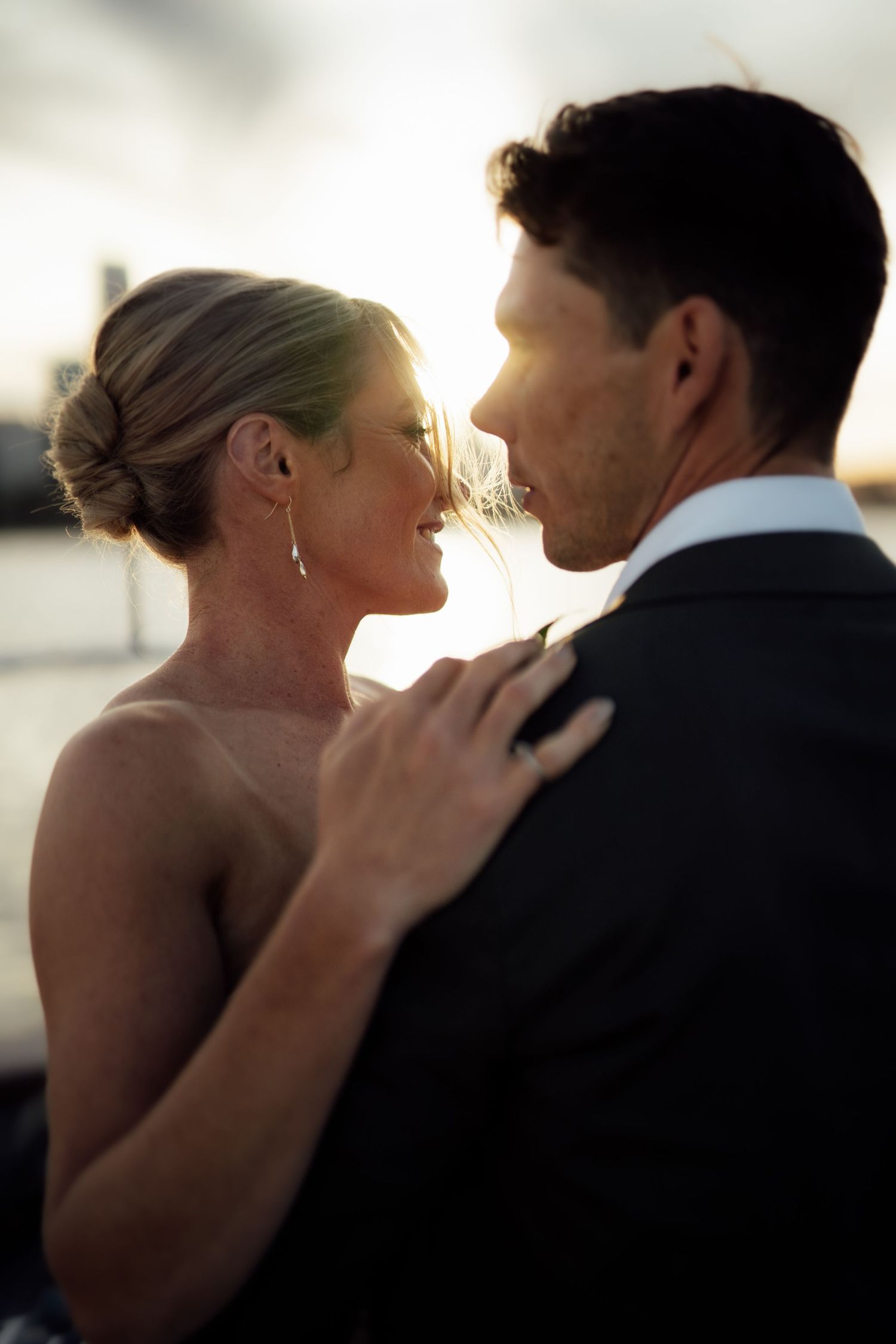 Intimate silhouetted couple embrace during sunset wedding photoshoot.