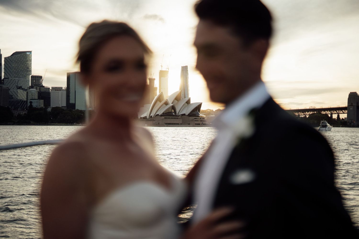A romantic sunset silhouette of newlyweds with a city skyline in the background.