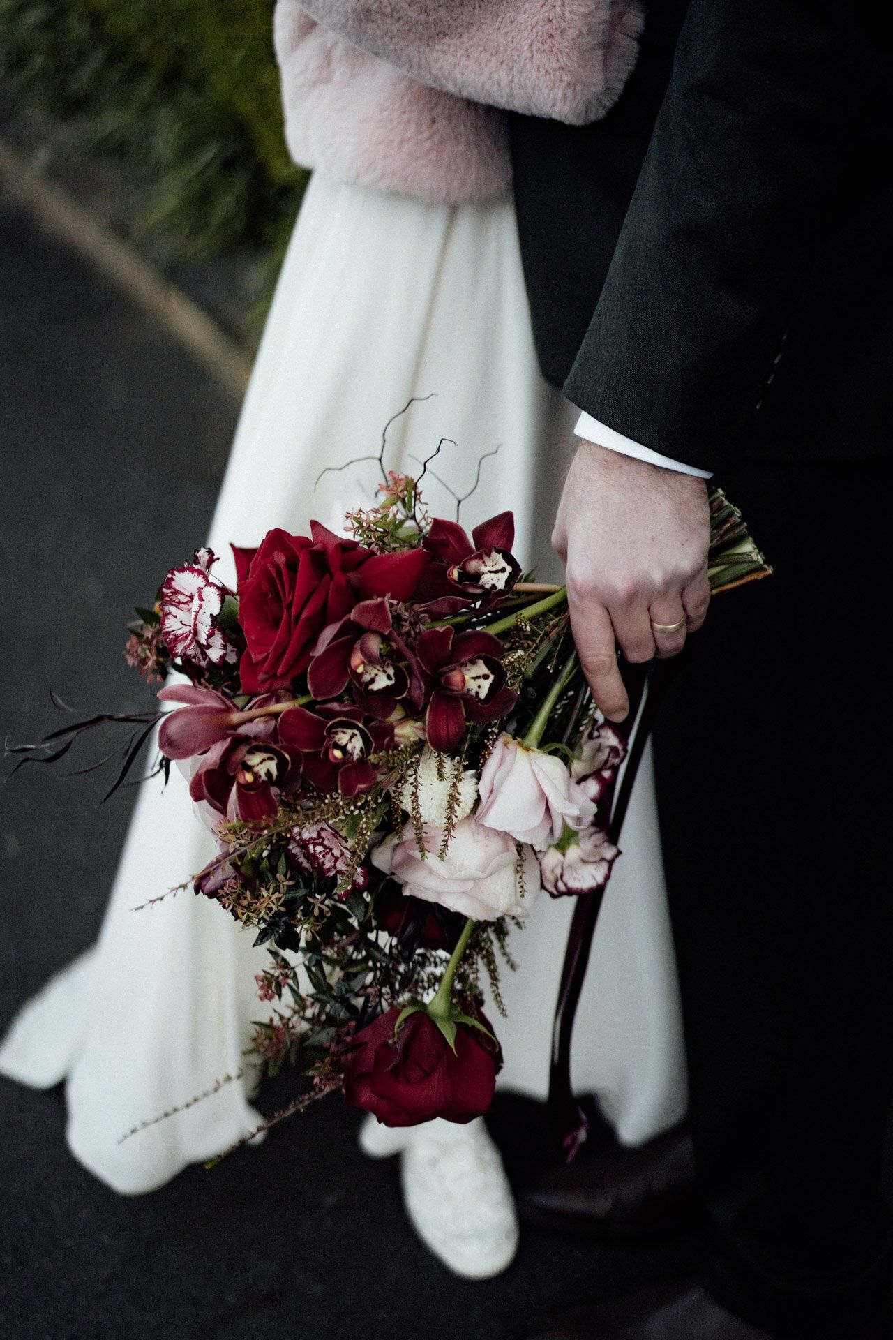 Close-up of a stunning burgundy and blush wedding bouquet with trailing elements.