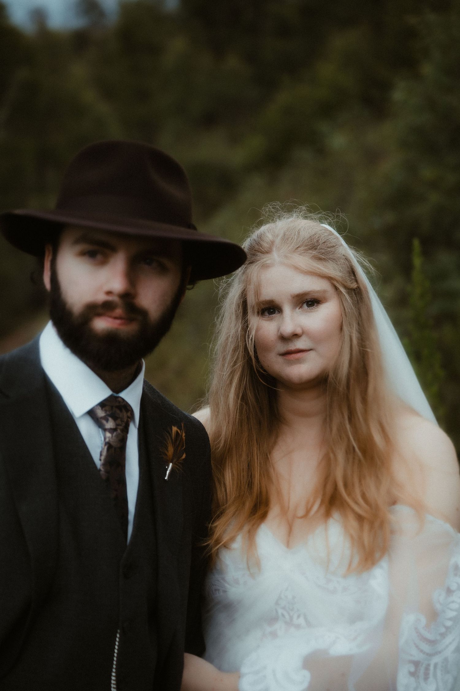 Artistic portrait of couple in western wedding attire with dramatic lighting.