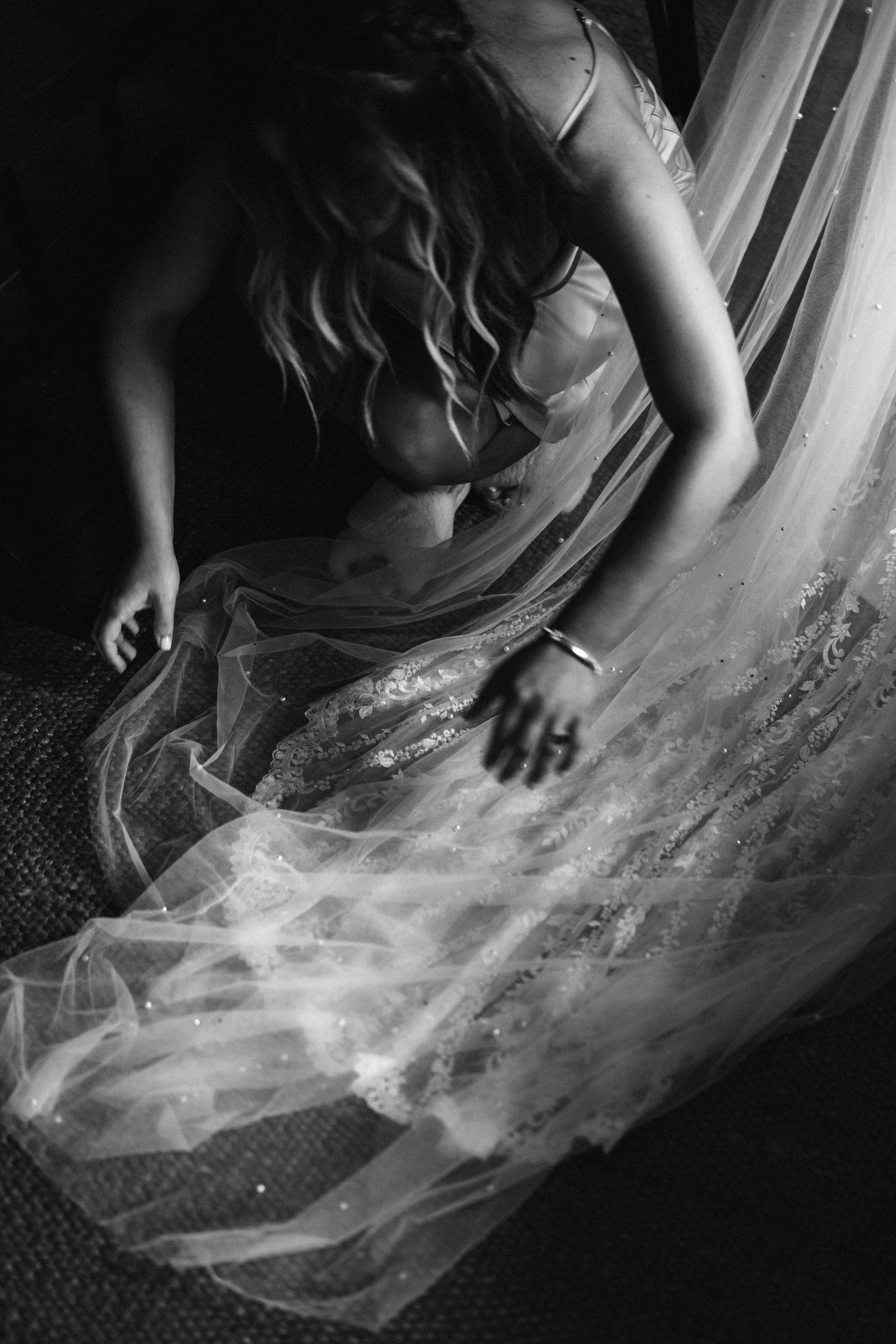 Close-up details of flowing white wedding dress fabric in dramatic black and white.