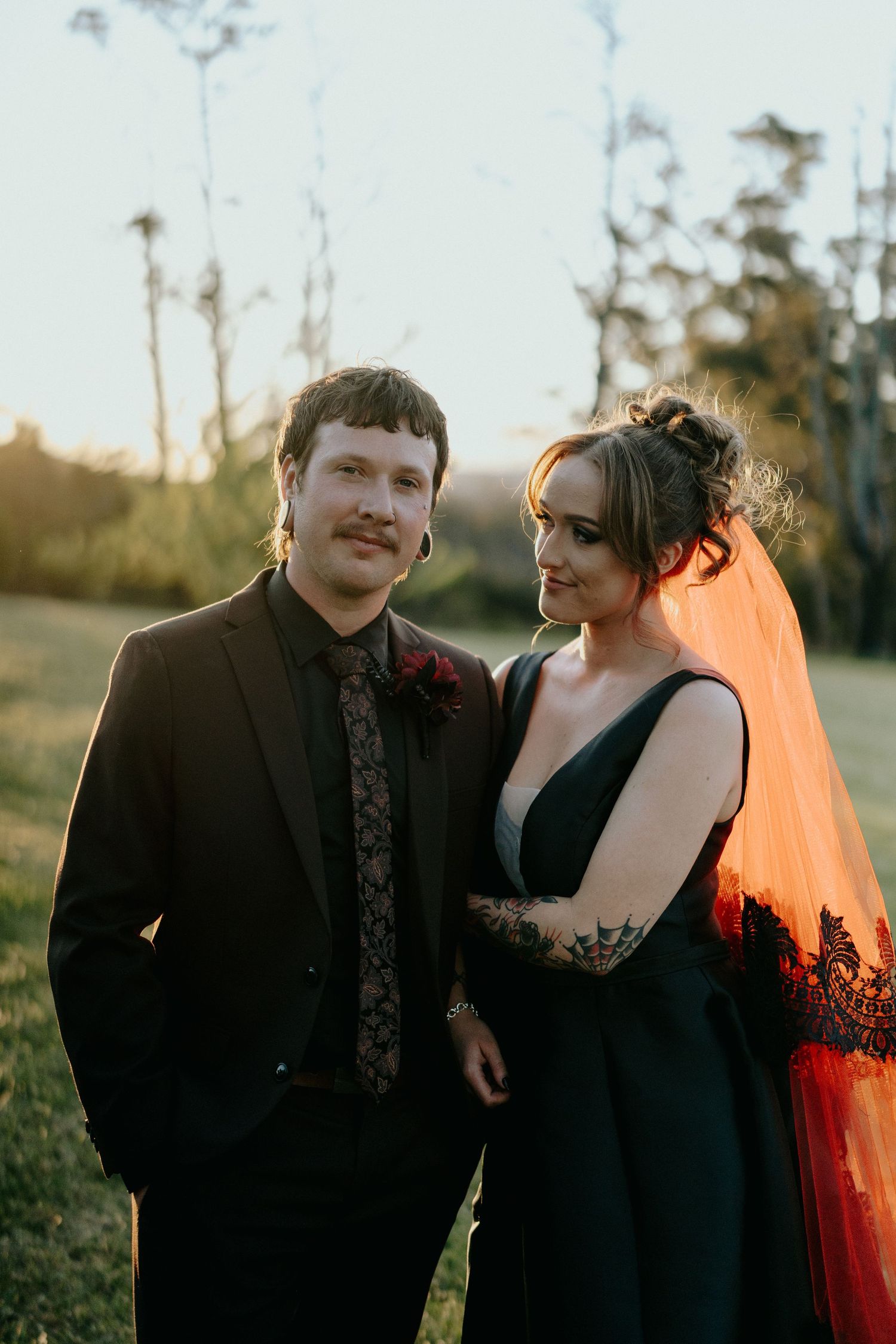 Couple shares intimate moment at sunset with warm orange glow illuminating their silhouettes.