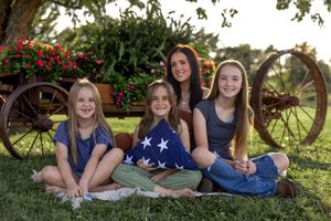 Outdoor group photo featuring American flag elements and rustic country backdrop.