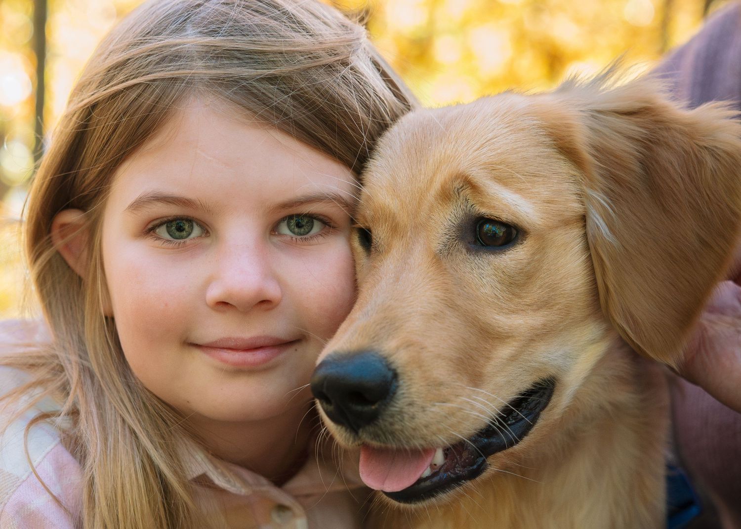 Portrait of young girl cuddling her dog; natural light family photography