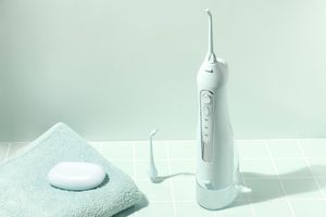 Irrigador dental inalámbrico blanco  limpieza bucal con modos suave, normal y pulso en baño moderno, fotografía de producto artistica en esp