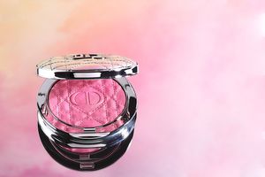 Luxuriöses Dior-Rouge mit gestepptem in silberner Kompaktverpackung, fotografiert von einem Produktfotografen vor pastellfarbenem Hintergrun