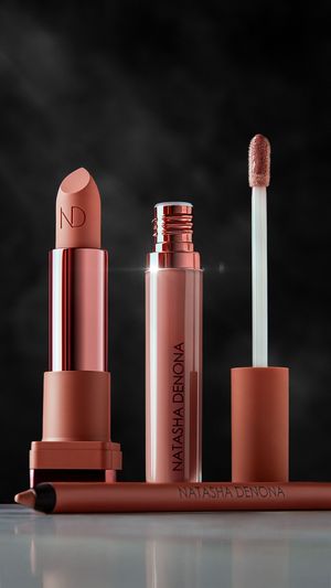 Lippenprodukte von Natasha Denona in Roségold-Nuancen vor dunklem Hintergrund, hochwertige Beauty Fotografie, verfügbar in der gesamten EU