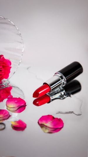 Red lipstick with rose petals and glass bowl, elegant beauty product photo by BOAfoto, for EU campaigns