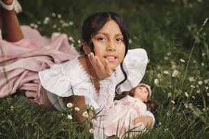 Niña con vestido de Comunión rodeada de vegetación en sesión fotográfica profesional en Vitoria-Gasteiz, Bilbao, Donosti, San Sebastian