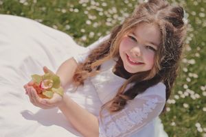 Niña de Primera Comunión con orchídea entre flores silvestres en sesión infantil, fotógrafo en Vitoria, Alava