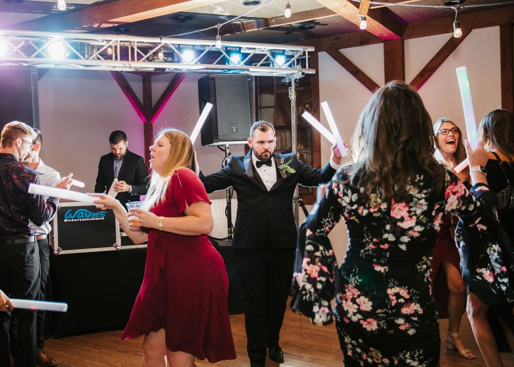 Lively dance floor scene at wedding reception with guests enjoying party atmosphere.