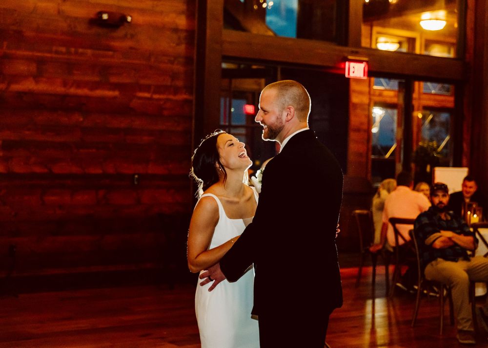 Intimate dance moment in warm-lit rustic wooden venue.