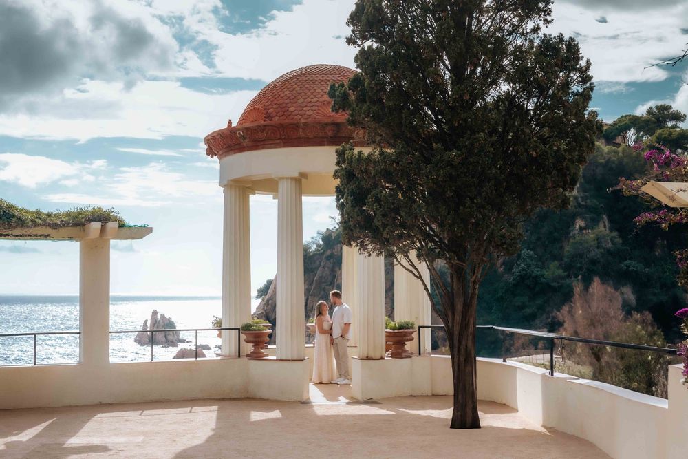 Valentina and Riley laughing on the cliffs of Jardí de Marimurtra during engagement shoot.
