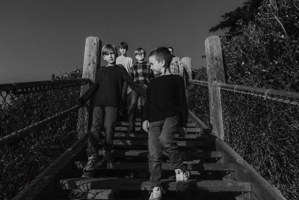 Black and white photo of people ascending wooden stairs outdoors.