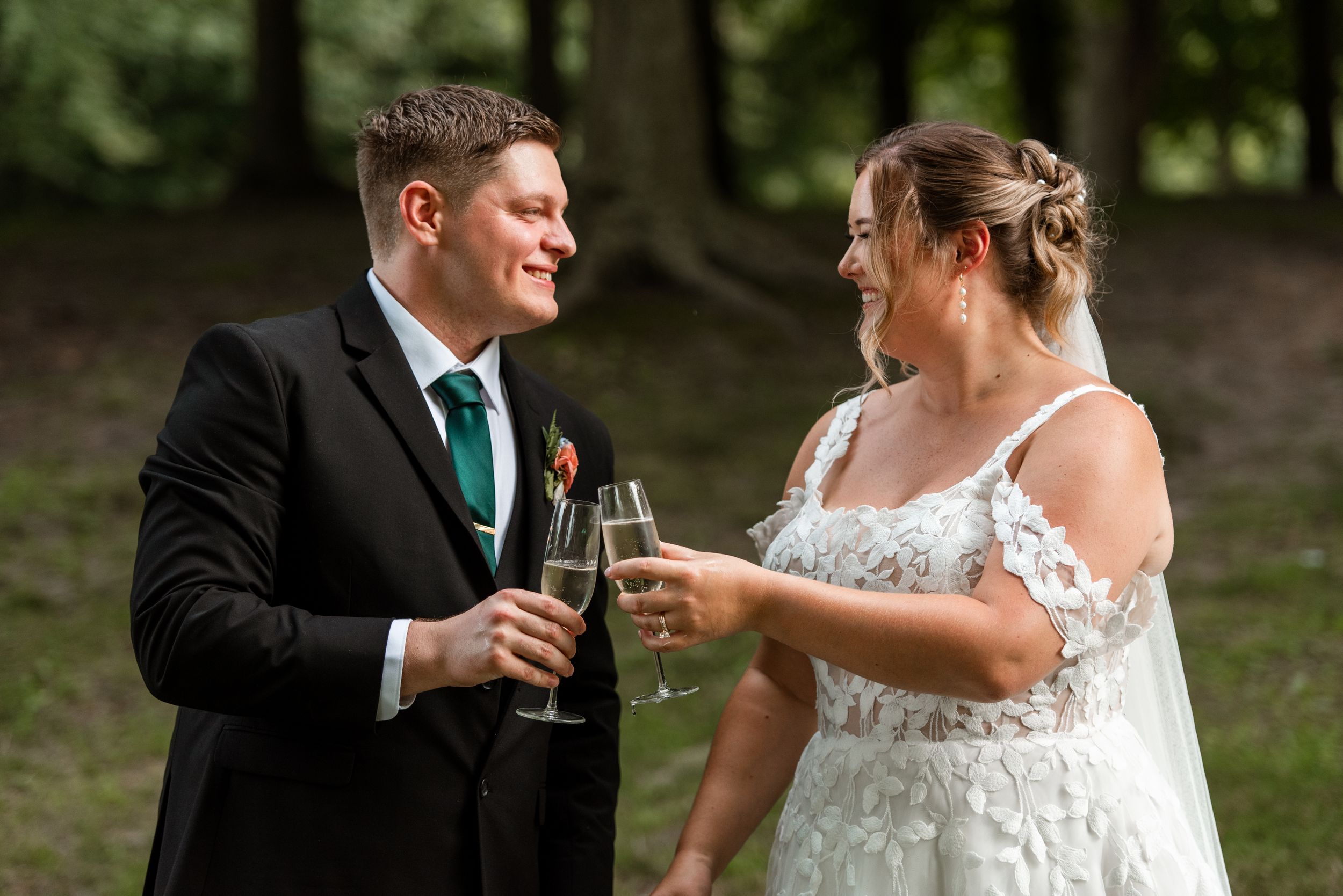 A couple shares a celebratory toast in a garden setting during their wedding ceremony.