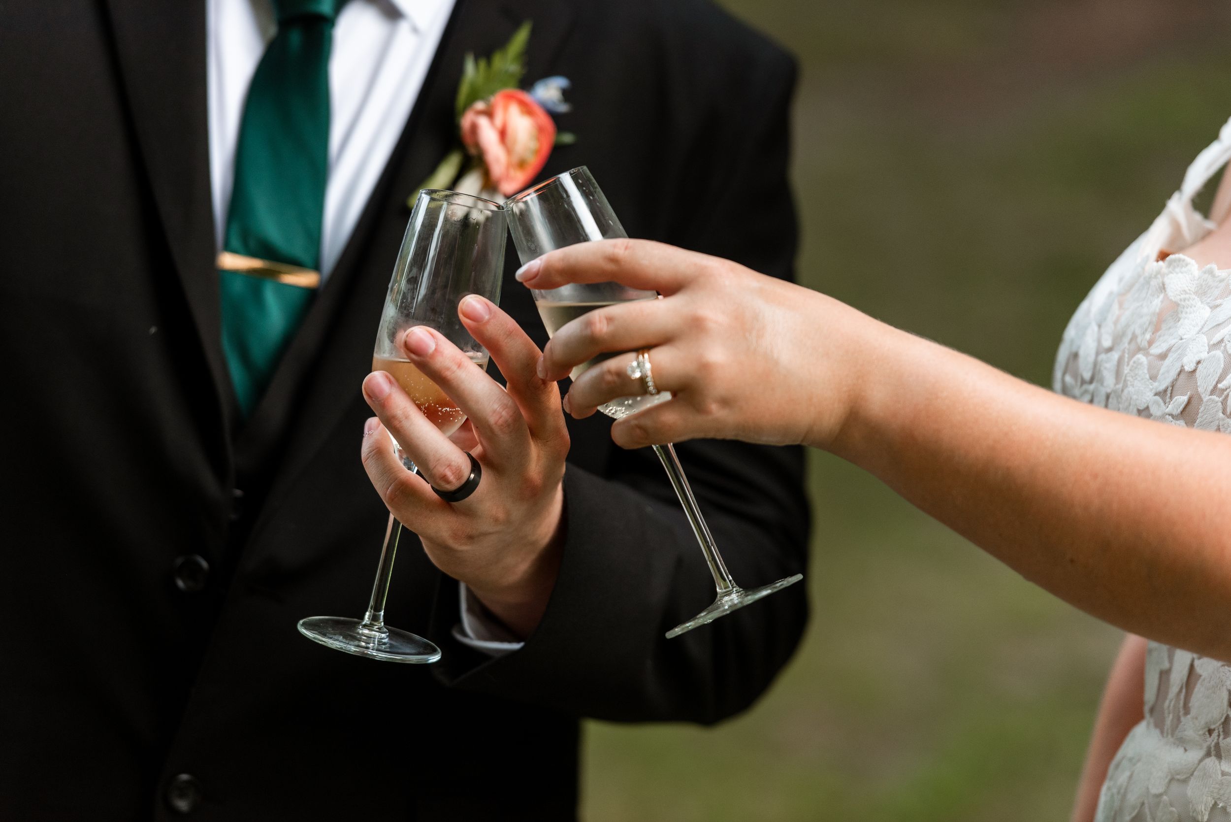 Wedding guests hold champagne glasses during an elegant outdoor reception celebration.
