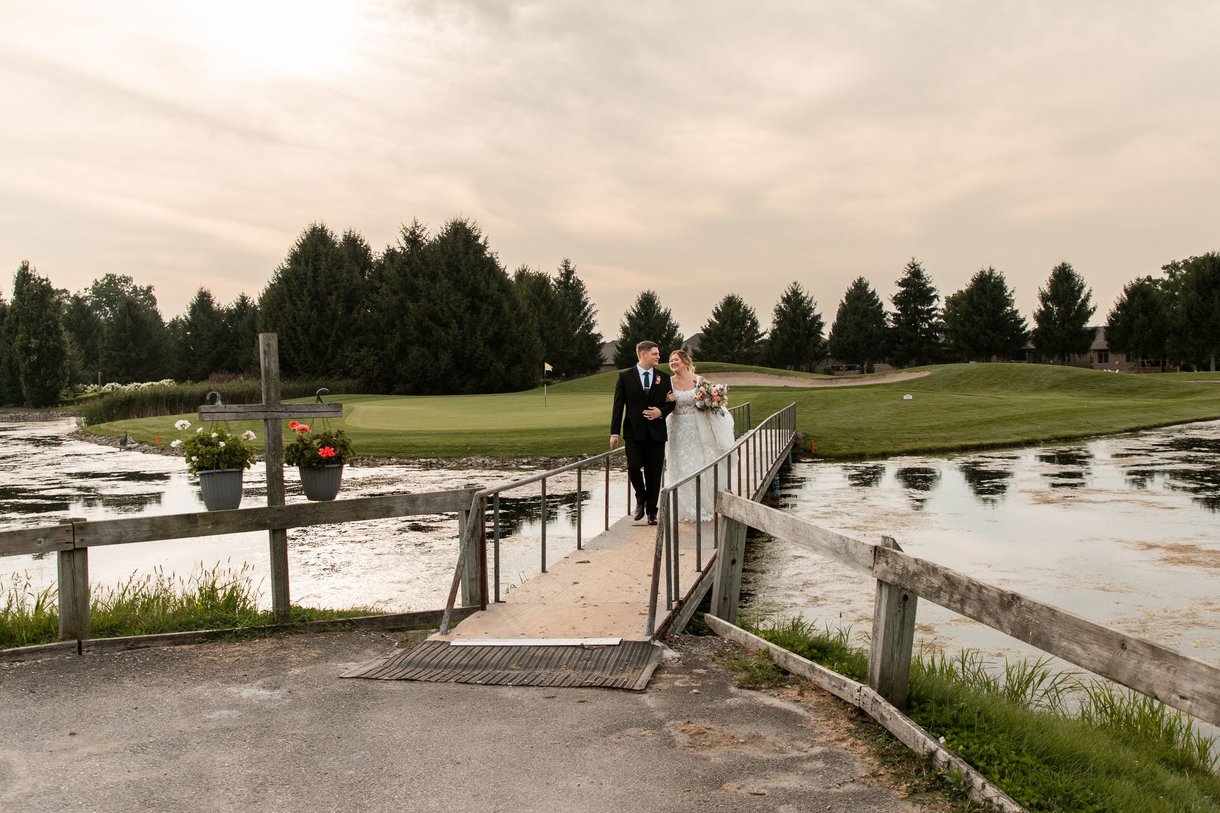 Panoramic view of a lakeside dock with pine trees and boats in the background during golden hour.