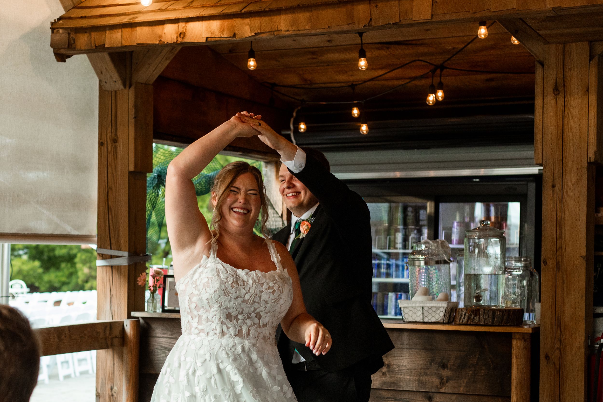 A rustic barn wedding venue with string lights and wooden beams creates a warm, romantic atmosphere.