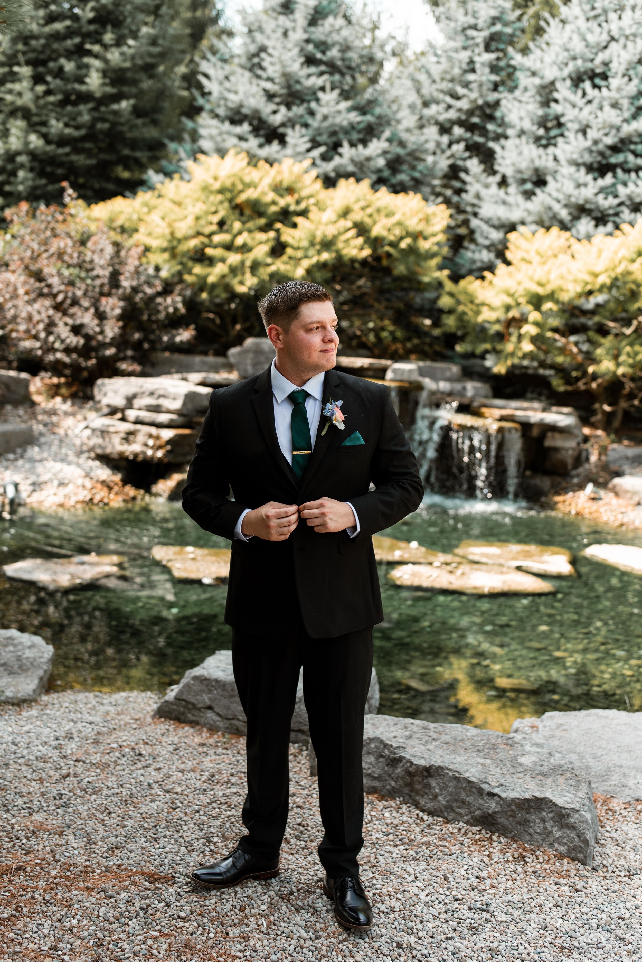 Groom Portrait Pose at Strathroy Caradoc Sands Golf Club in front of the waterfall with autumn foliage in the background.