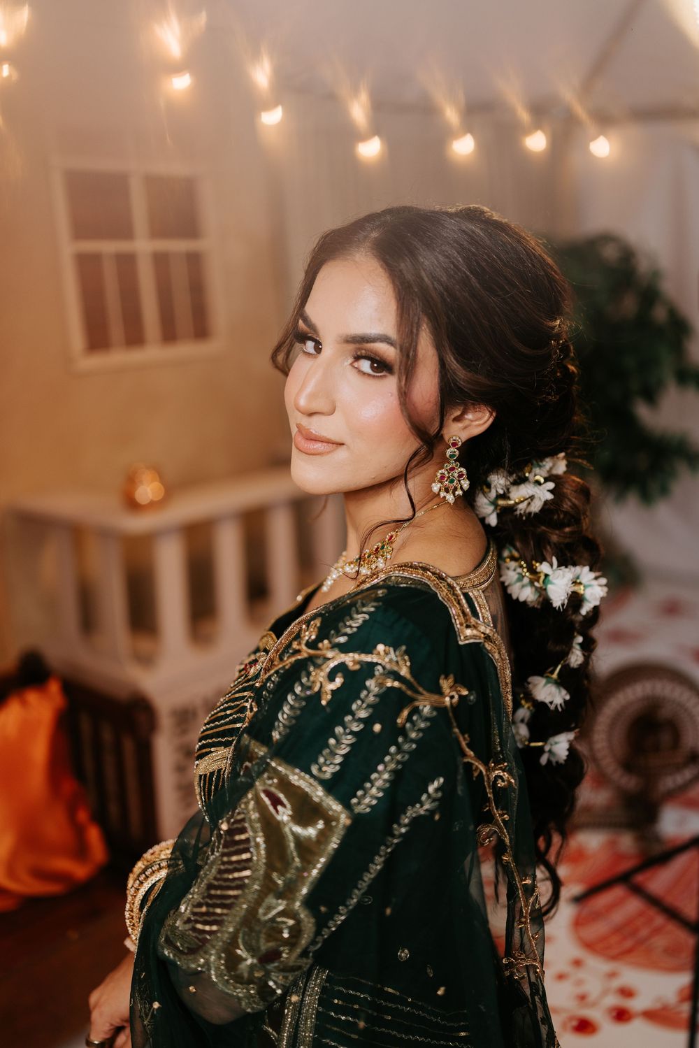 Detailed embroidered black traditional dress with gold accents shown from multiple angles in a warmly lit setting.