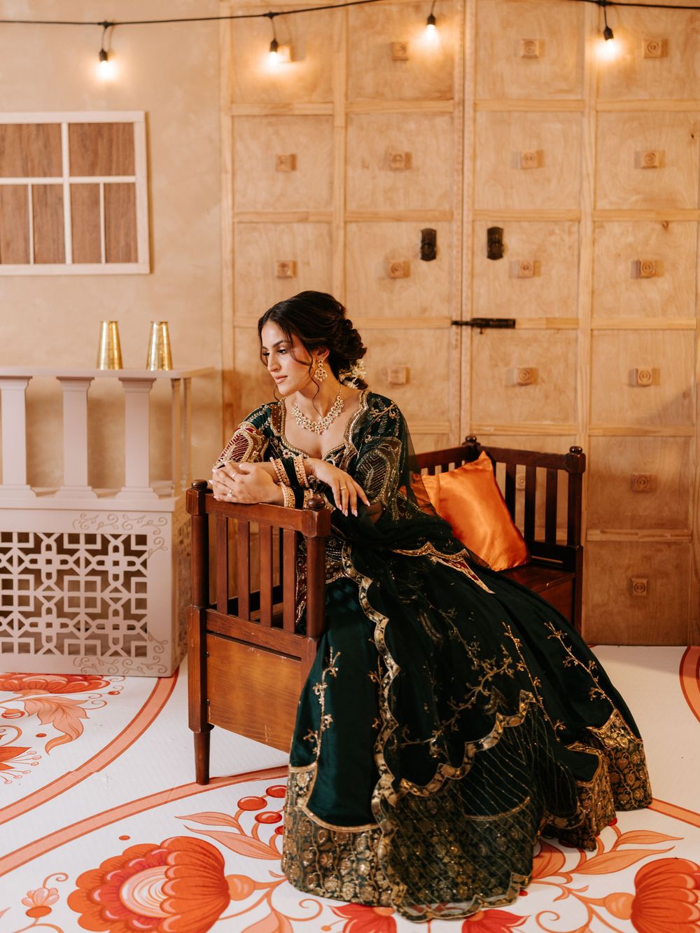 Ornate black and gold lehenga dress adorned with intricate embroidery in a warmly lit room with string lights.
