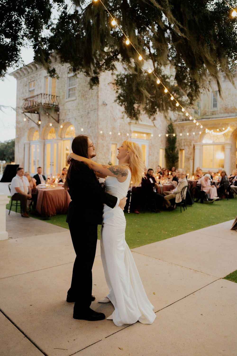 A romantic evening dance sequence at an elegant white mansion with Spanish moss draped trees and glowing lights.