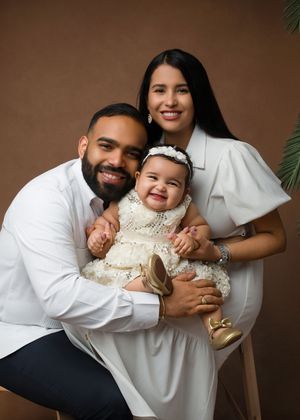 A family in white outfits poses for a series of candid photos showing their affection and joy together.