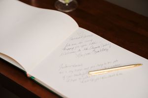 Handwritten notes and papers scattered on a dark wooden desk surface.