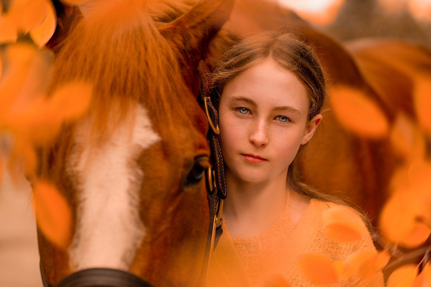 Artistic portrait photo with warm orange tones and soft lighting creates a dreamy atmospheric effect.