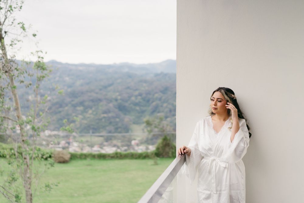 Elegant white lace robe photographed against mountain landscape backdrop.