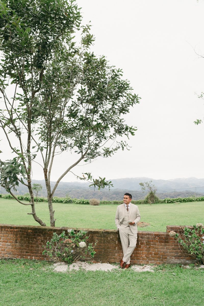 A series of four romantic outdoor portraits against a rustic brick wall and scenic countryside landscape.