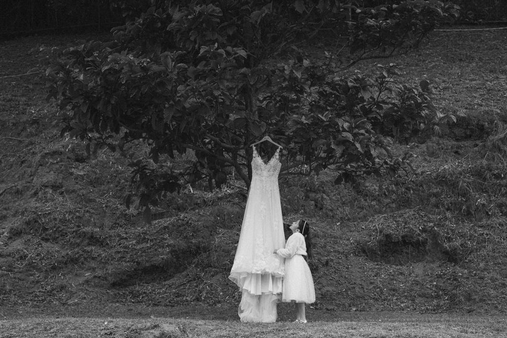 A series of black and white photographs showing a person in white dress walking through a wooded area.