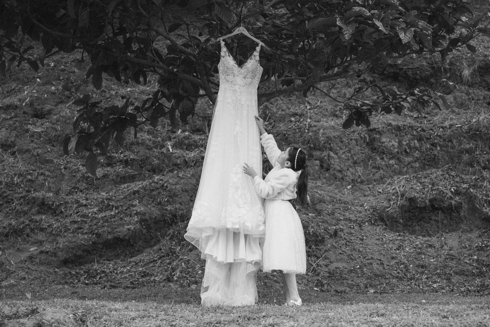 A series of black and white wedding photos showing a couple walking through a garden setting.