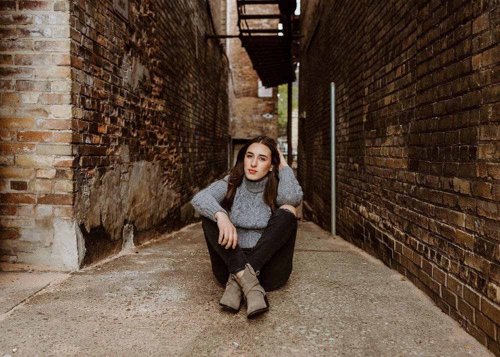 Artistic portraits in an urban brick alleyway.