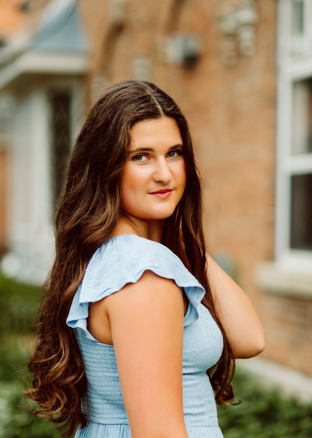 Portrait series showing a light blue summer dress against a brick wall background.