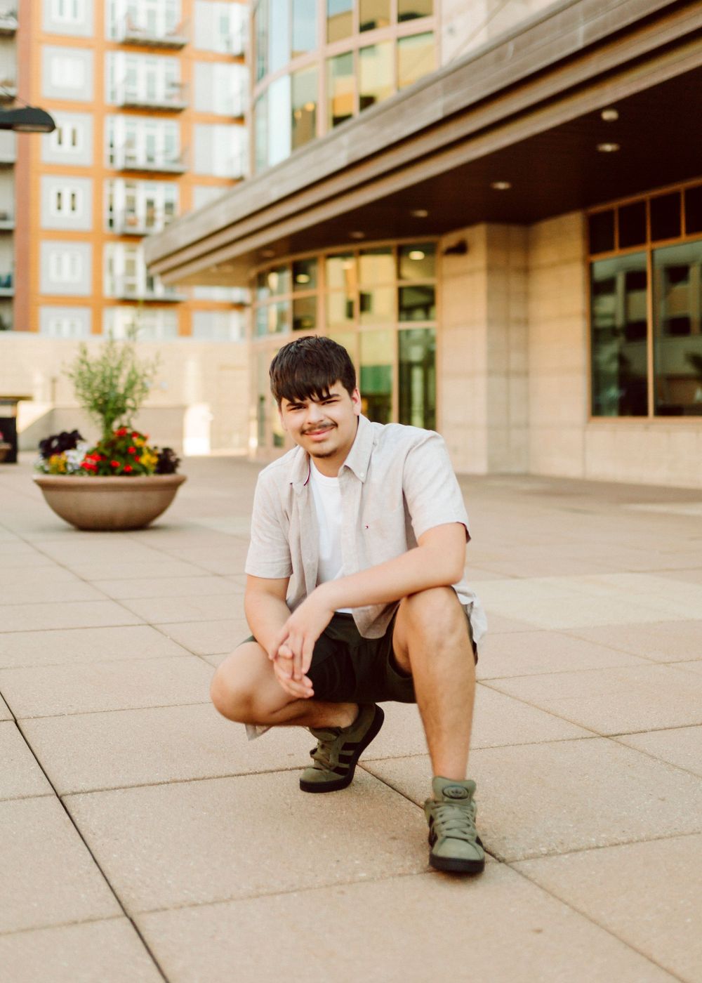Urban fashion photoshoot featuring casual wear and relaxed poses on a concrete plaza.