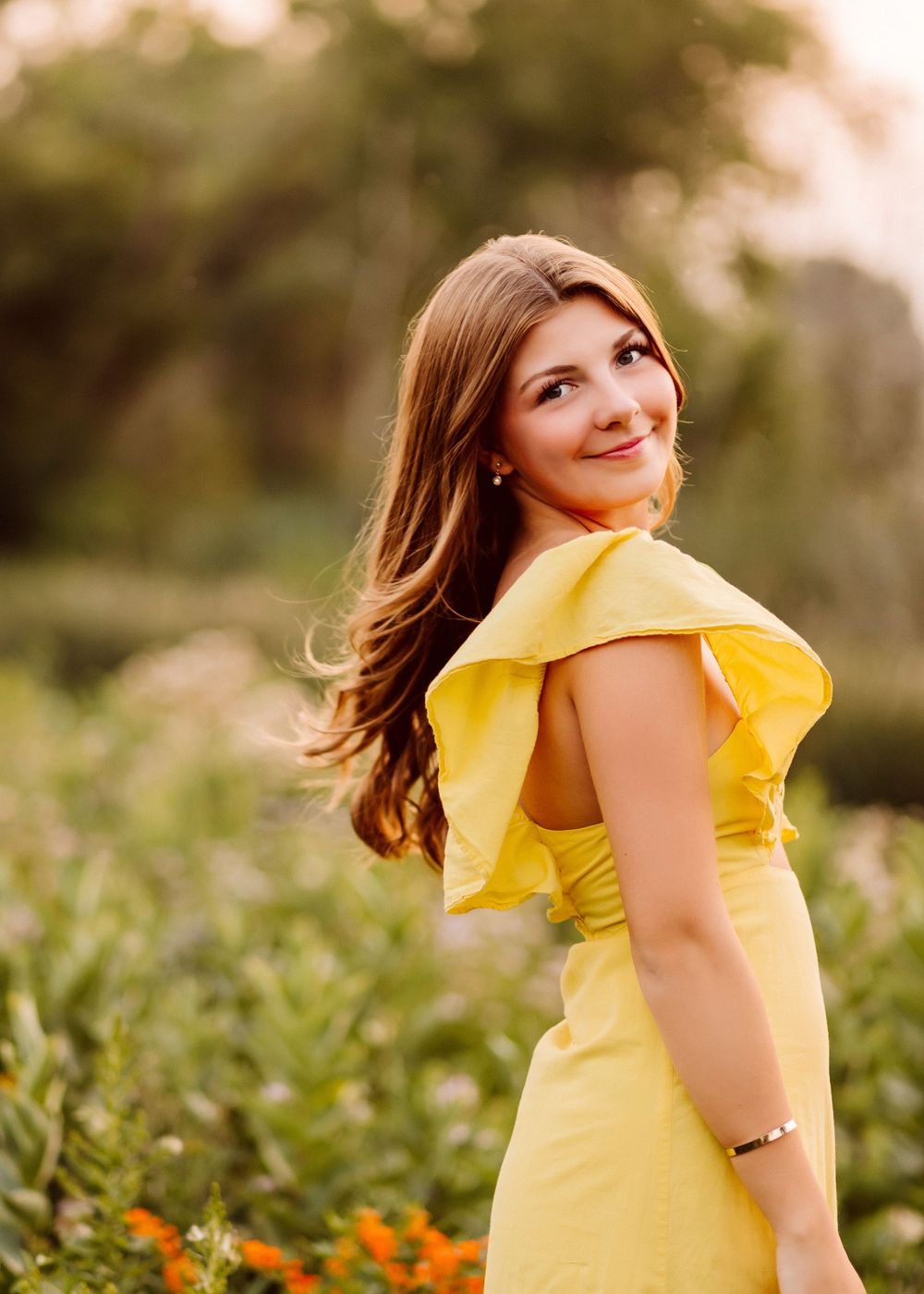 Bright yellow dress creates stunning contrast against natural outdoor setting.