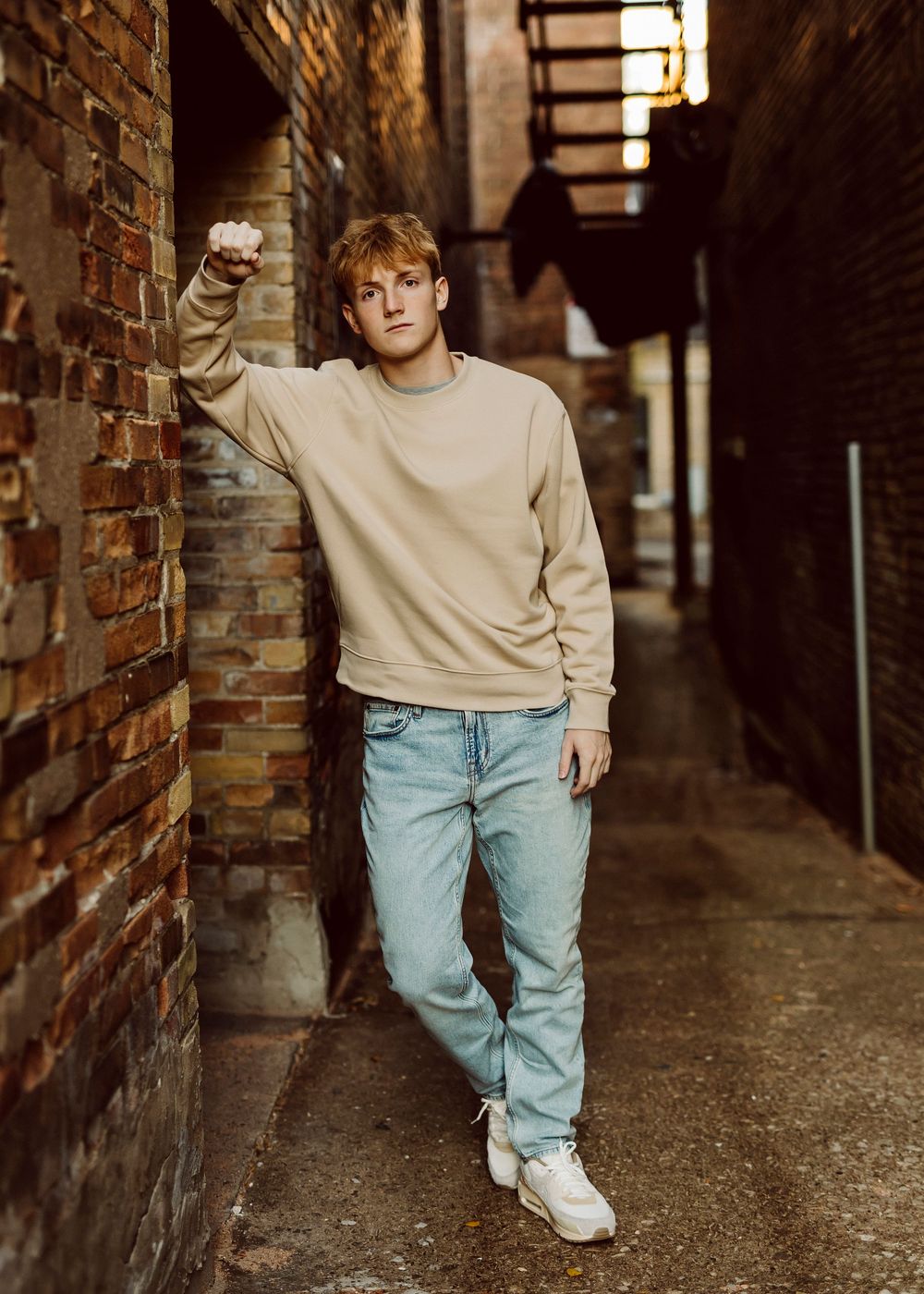Fashion portraits in casual wear walking through brick corridor.