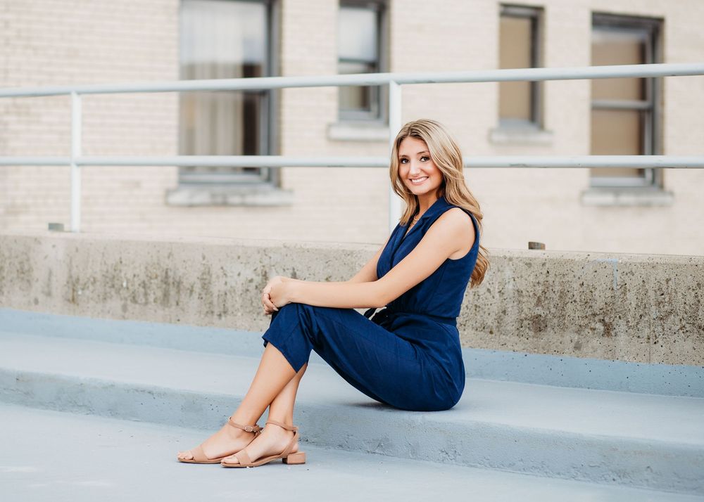 Artistic photo series showing relaxed poses along concrete walkway in navy dress.