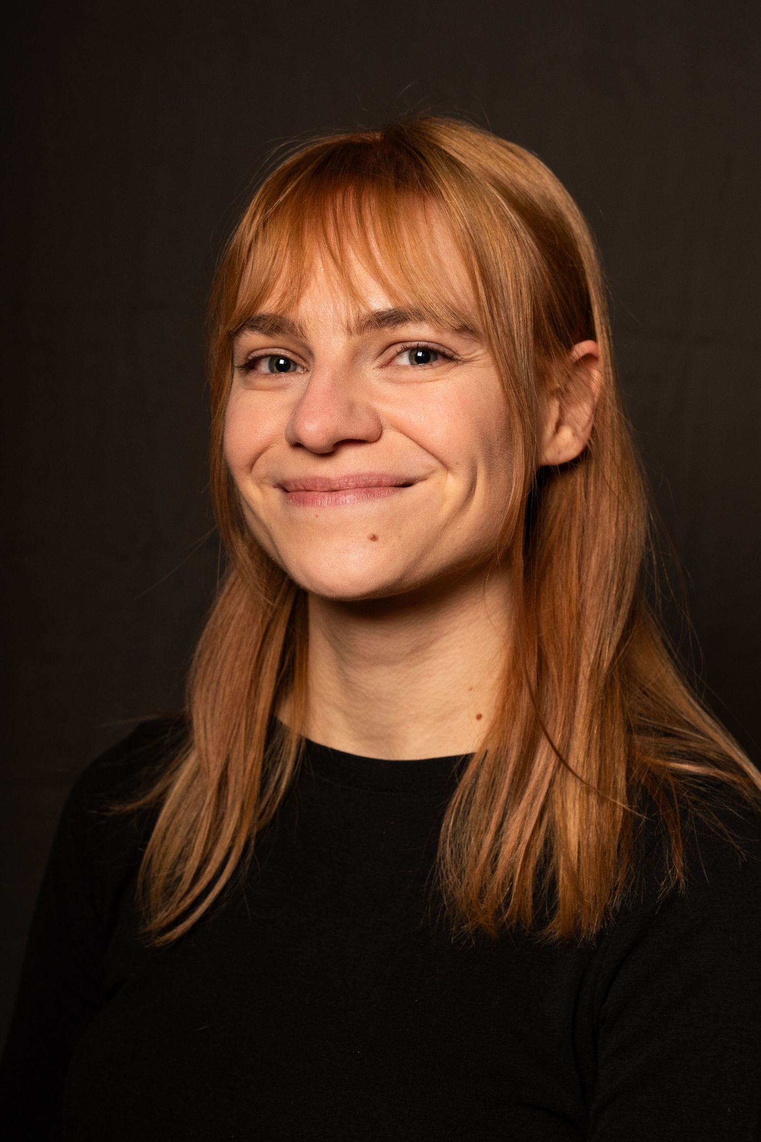 headshot photography. Brighton. headshot of actress with red hair and black top. smiling