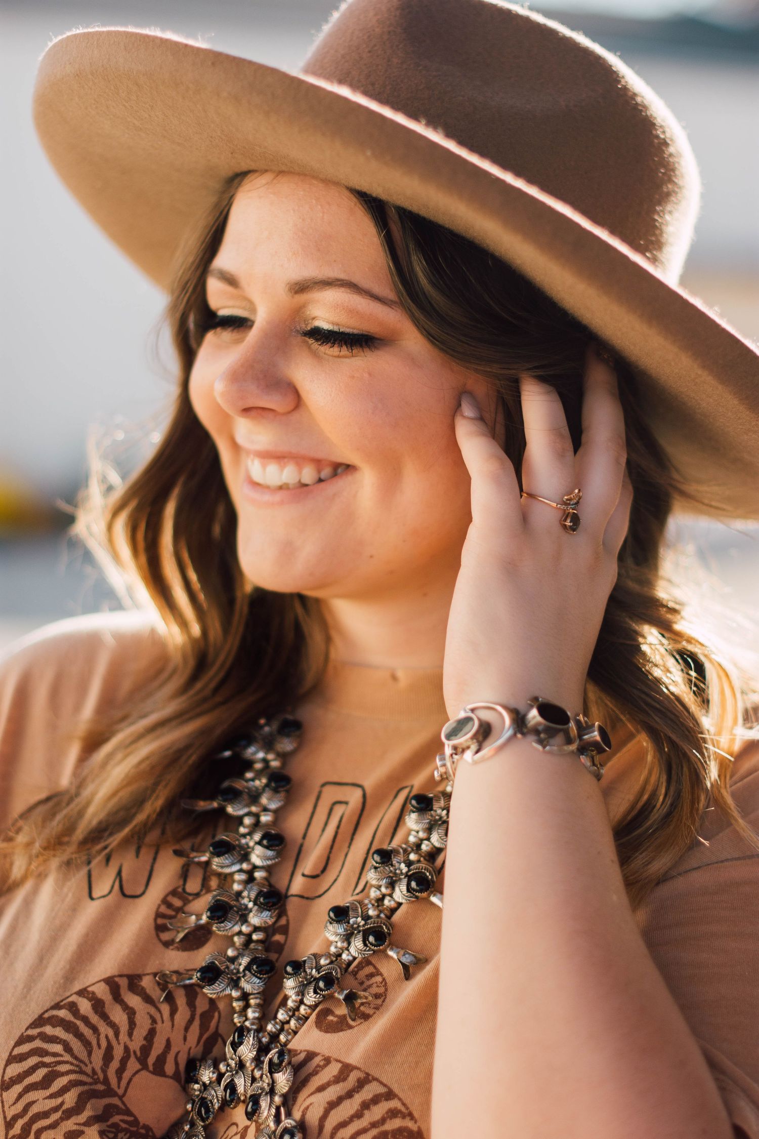 Stylish portrait series wearing brown hat and statement necklace.