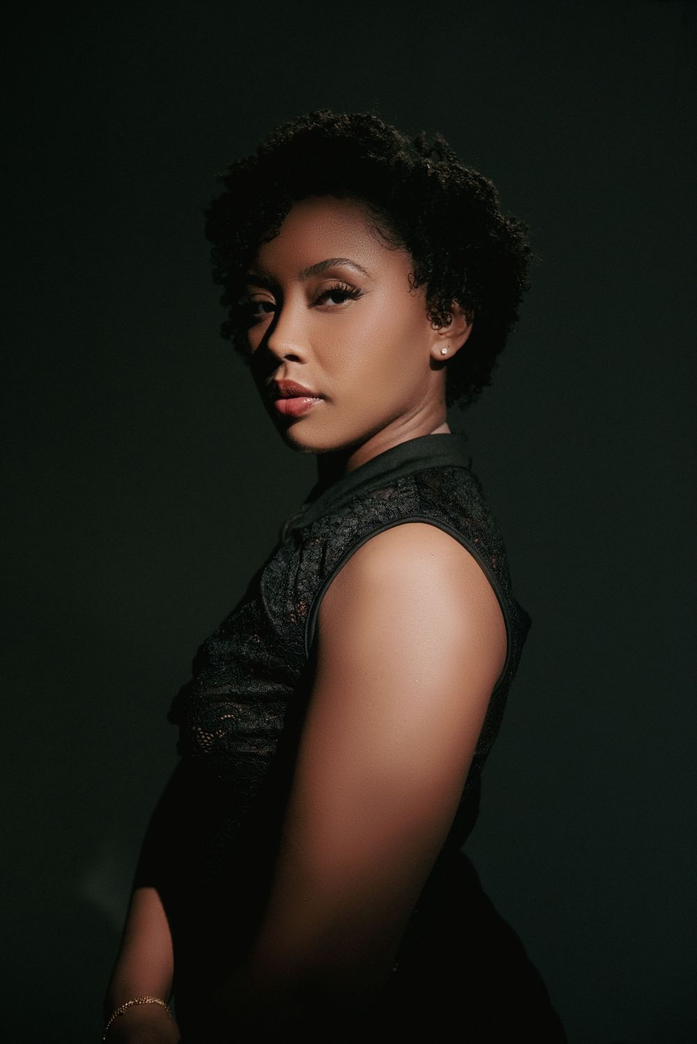 A dramatic portrait series in dark lighting shows a person wearing black against a dark background with red lipstick.