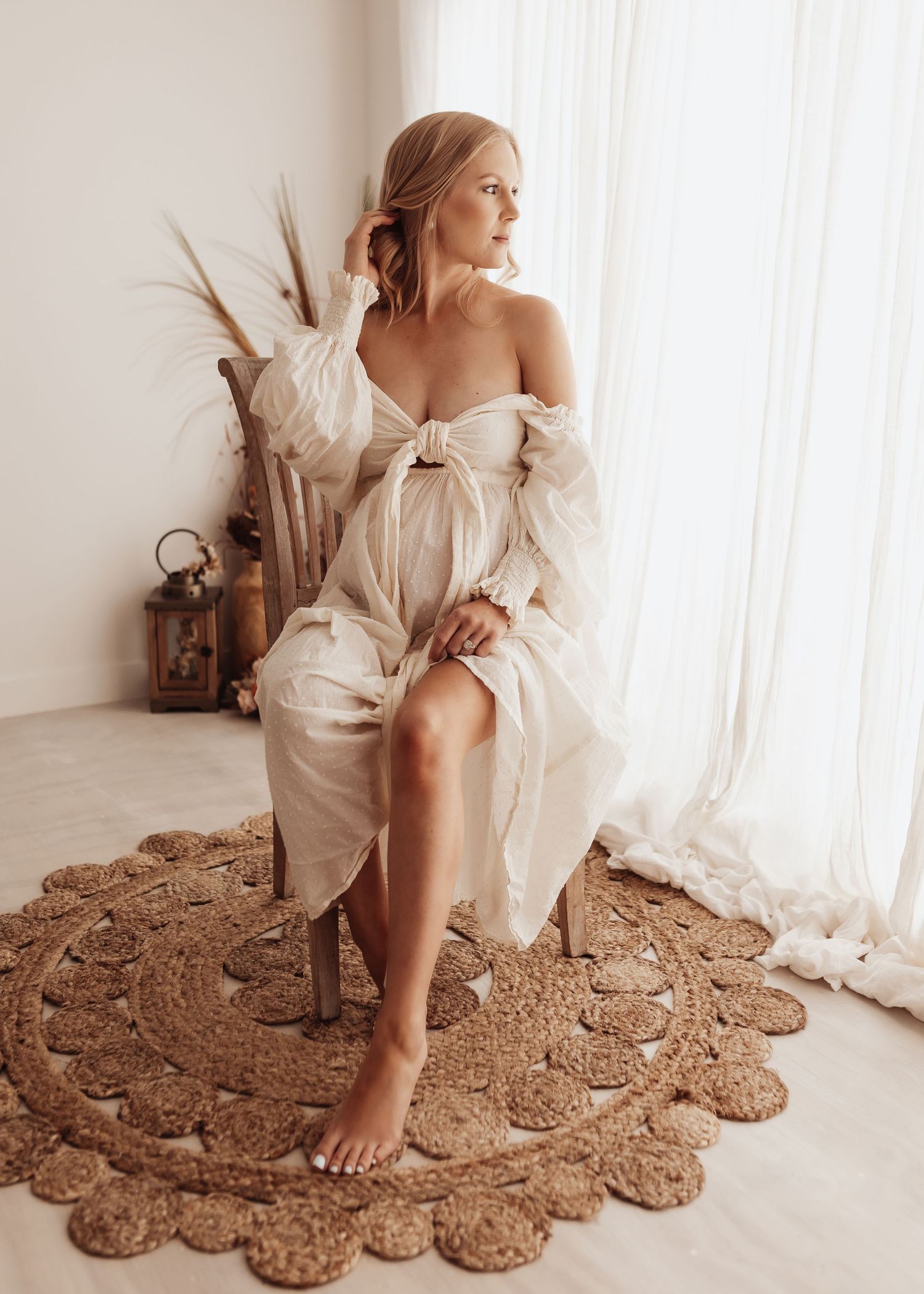 Ethereal portrait in white dress with dried floral arrangements and vintage decor.